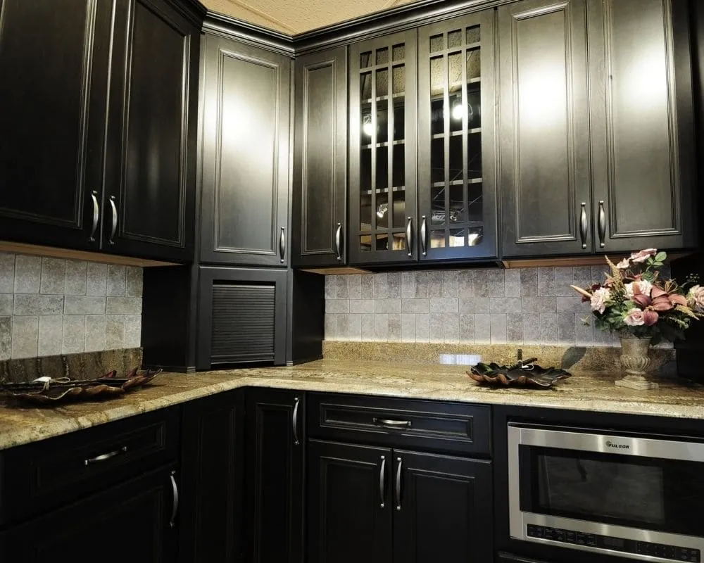 After: the same kitchen with the cabinetry sprayed a deep matte black against the original granite