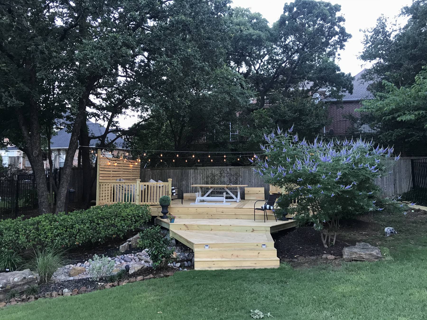 Garden deck and fencing seen across a mown lawn