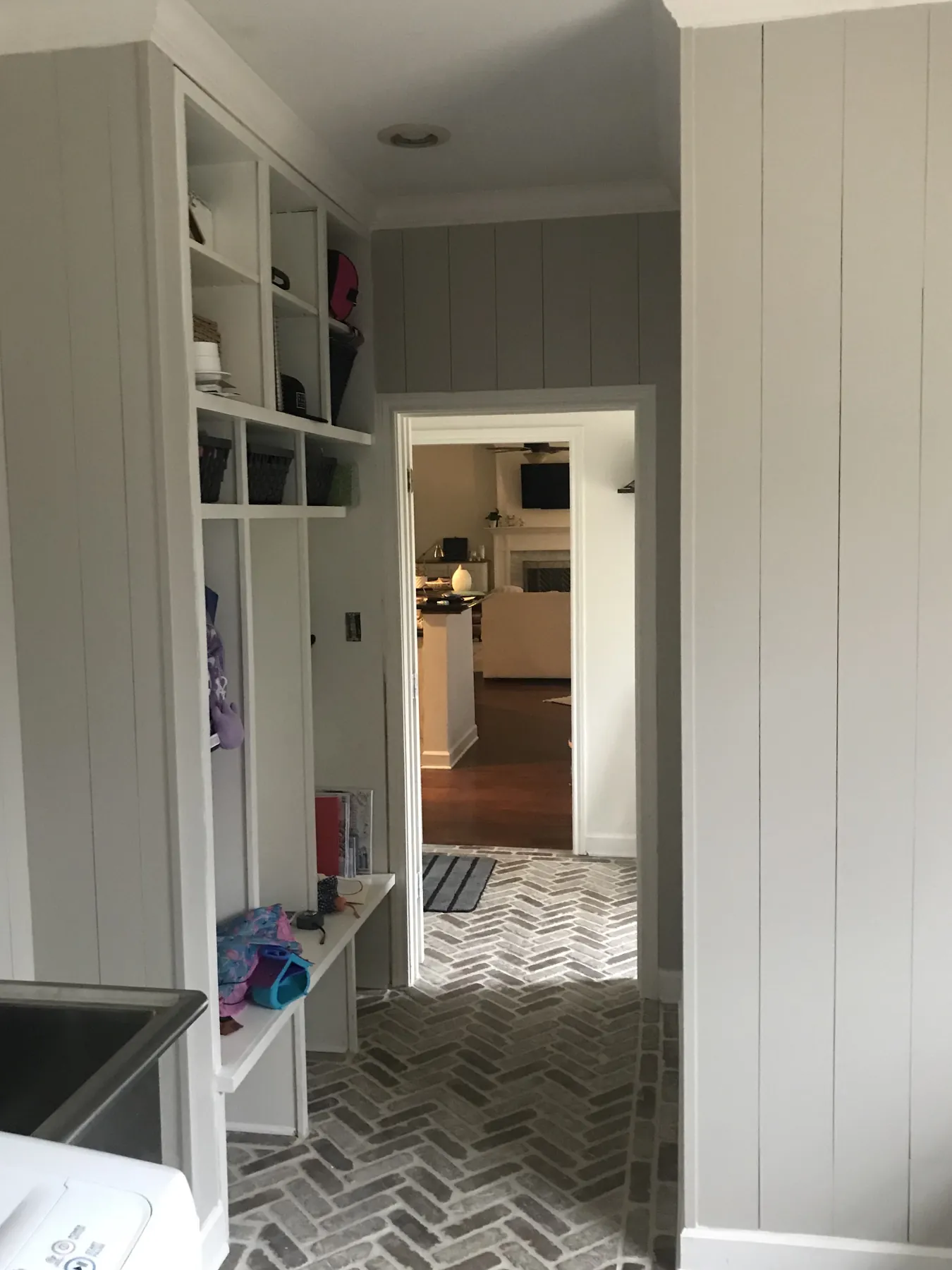 Built-in mudroom lockers with hooks and bench seating, painted white